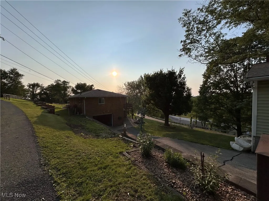Property exterior at dusk featuring a lawn