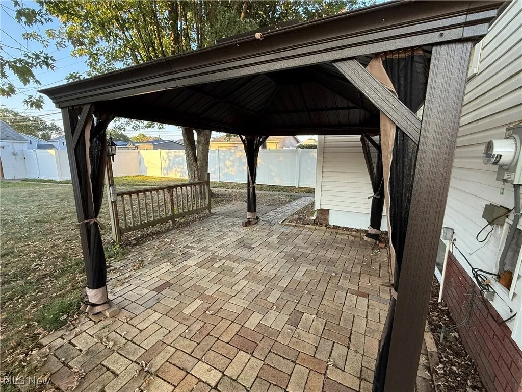 Fenced backyard featuring a gazebo and a patio
