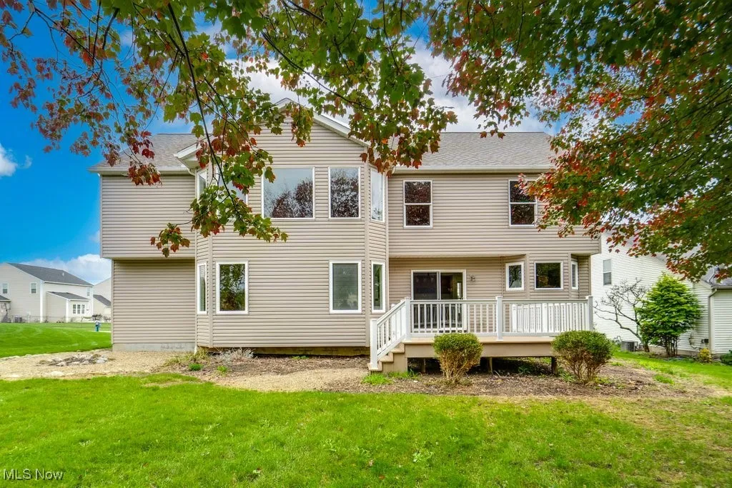 Rear view of property featuring a deck and a lawn
