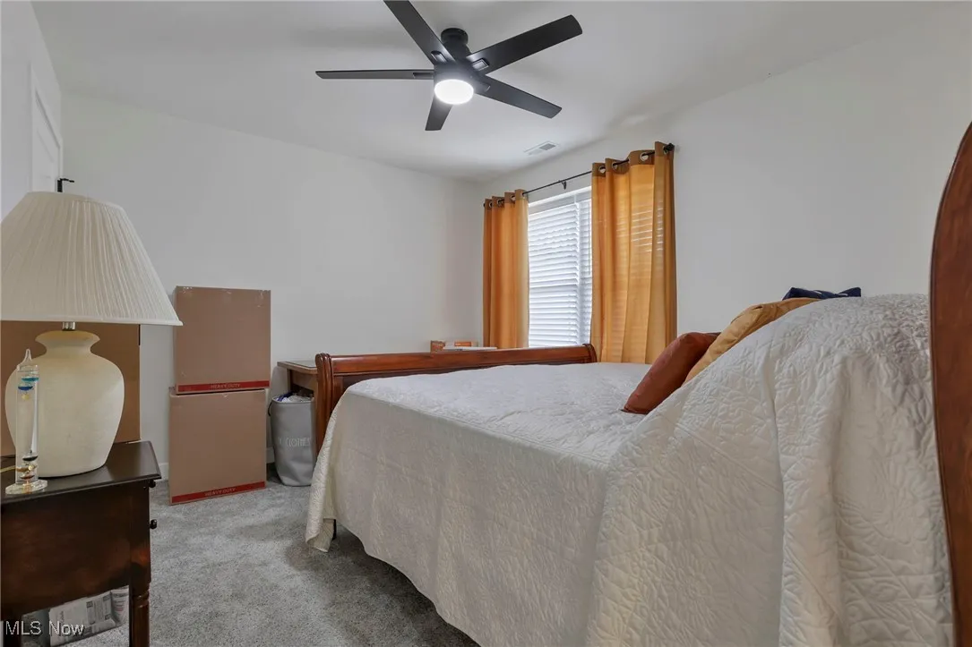 Bedroom featuring light carpet and a ceiling fan
