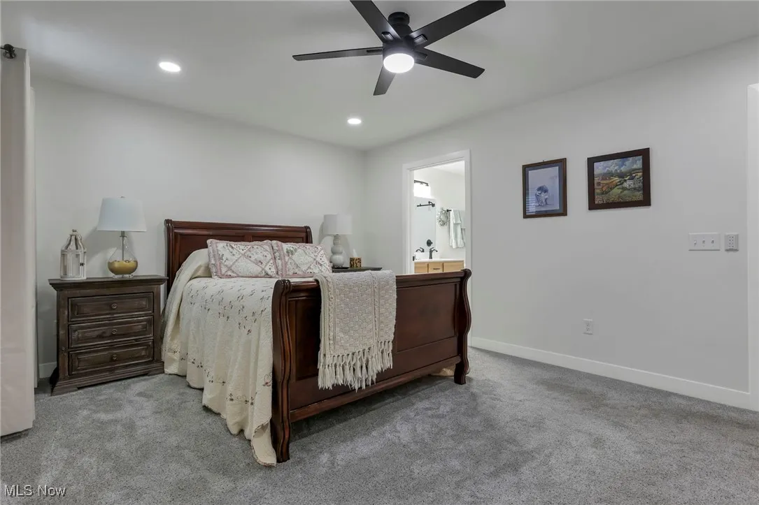 Bedroom with carpet floors, recessed lighting, ceiling fan, and ensuite bath