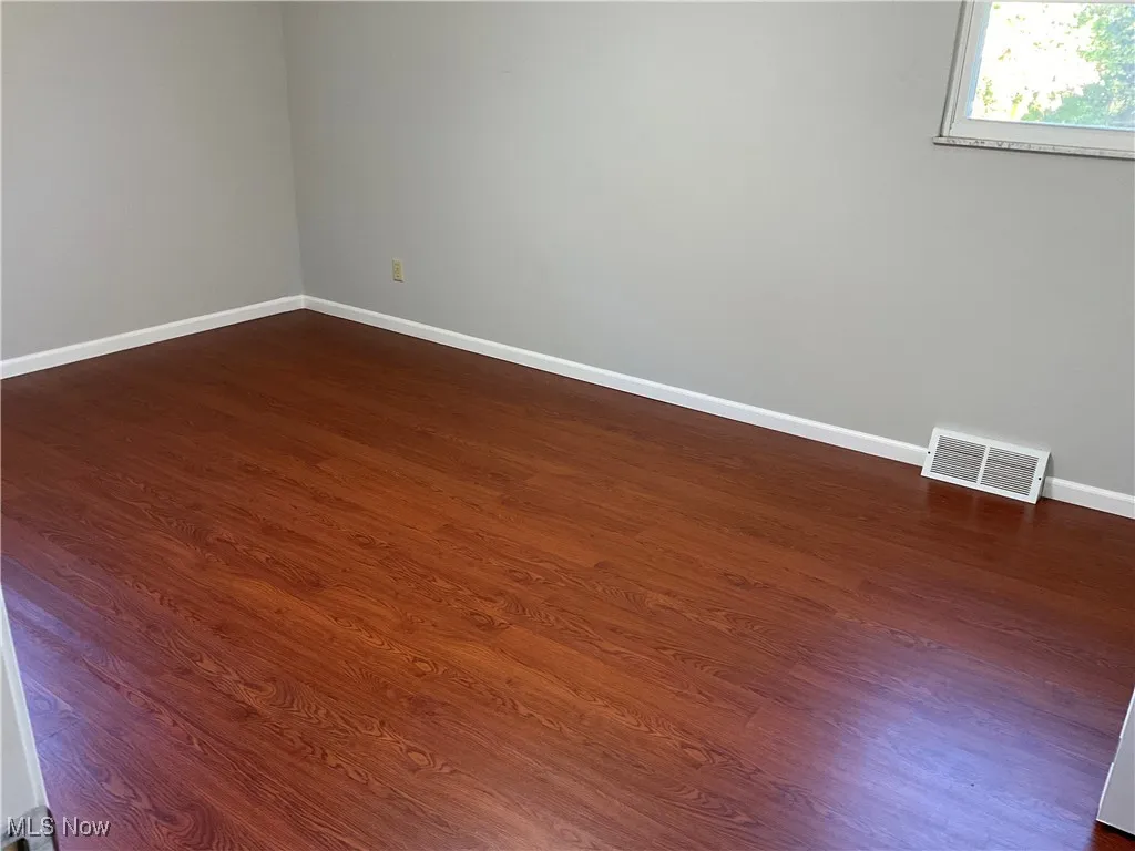 Spare room featuring dark wood-type flooring