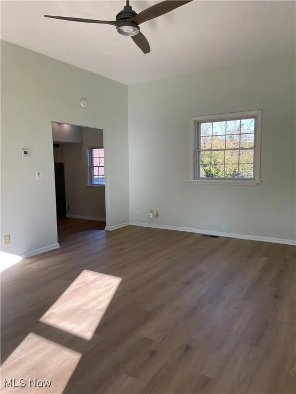 Spare room featuring dark wood finished floors, ceiling fan, and a textured ceiling