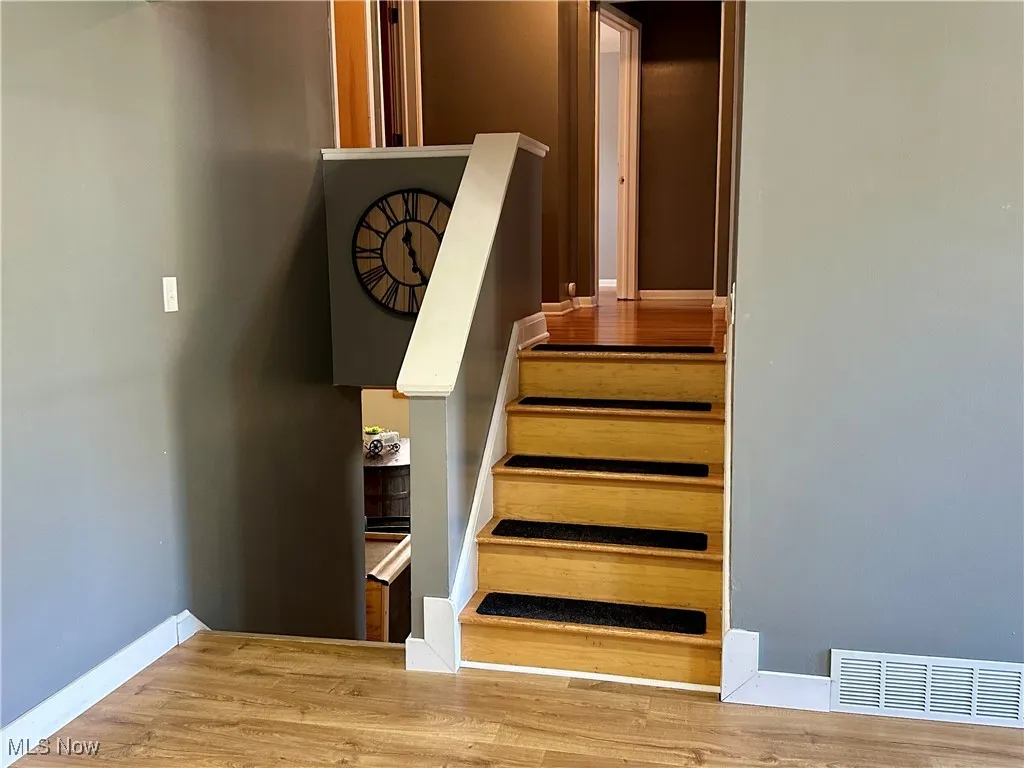 Staircase featuring wood finished floors