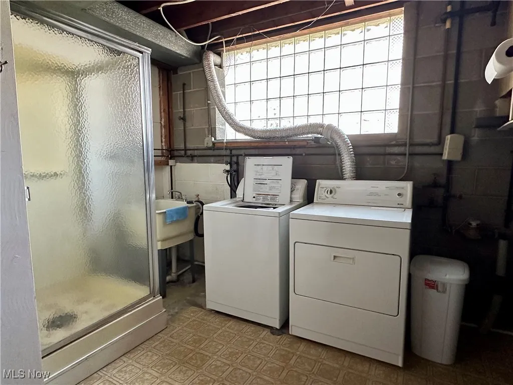 Laundry room featuring light flooring and washing machine and clothes dryer