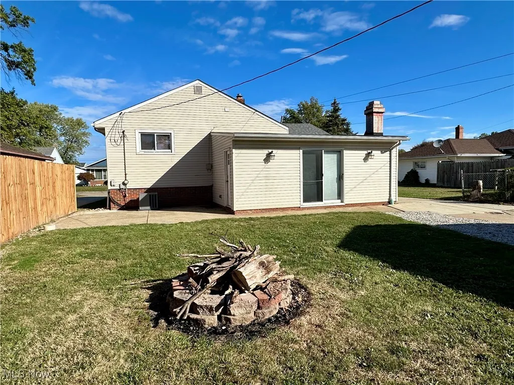 Back of property featuring a chimney, an outdoor fire pit, and a patio