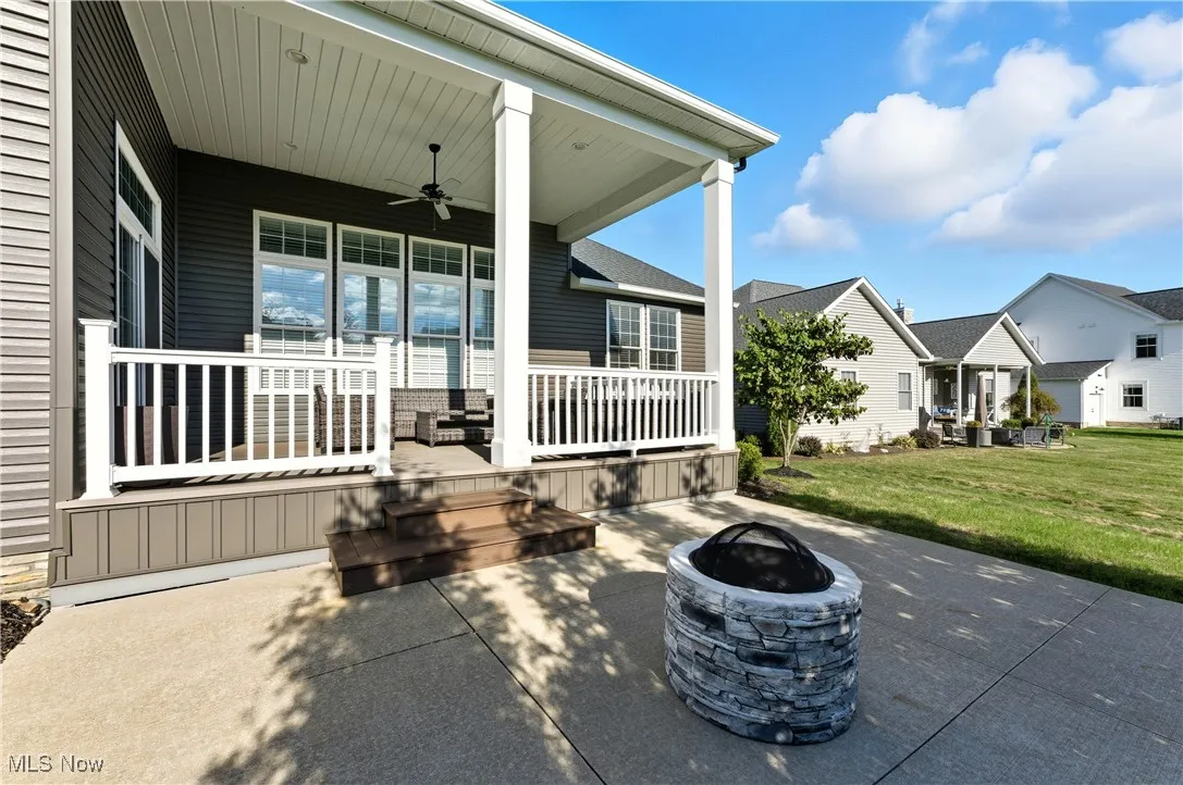 View of patio / terrace featuring a ceiling fan, a fire pit, and a residential view