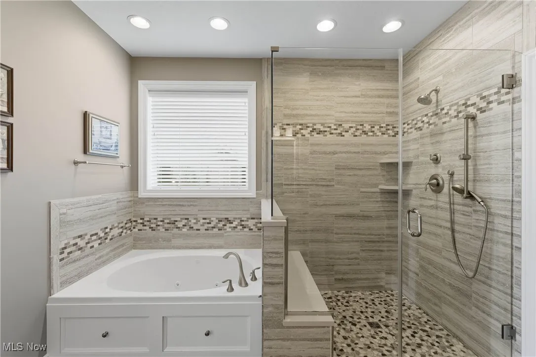 Bathroom featuring a jetted tub, a shower stall, and recessed lighting