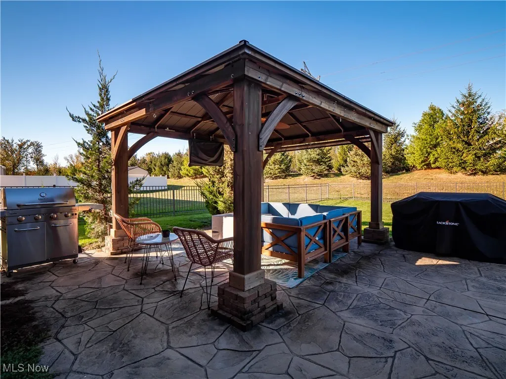 Fenced backyard featuring grilling area, a patio, outdoor lounge area, and a gazebo
