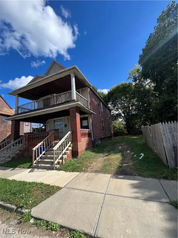 View of front of property featuring covered porch and brick siding