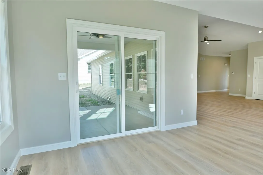 Doorway with wood finished floors and a ceiling fan