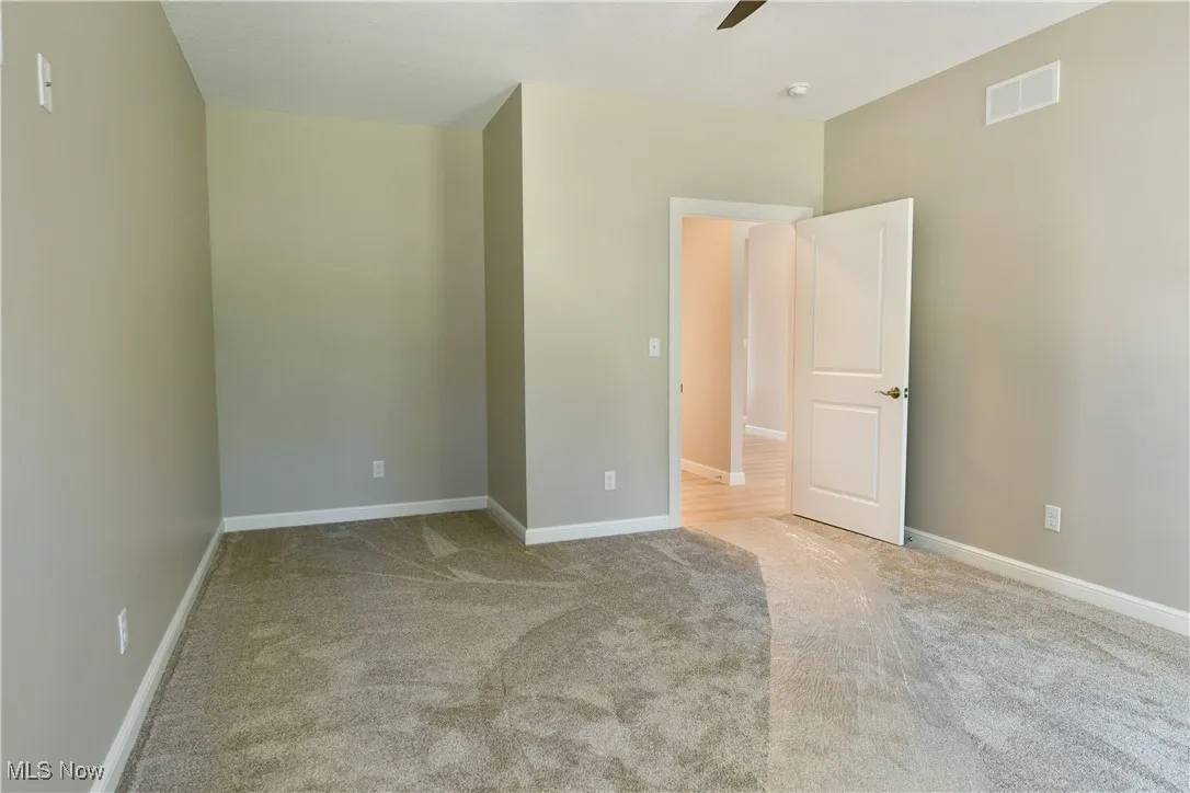Spare room featuring light carpet and a ceiling fan