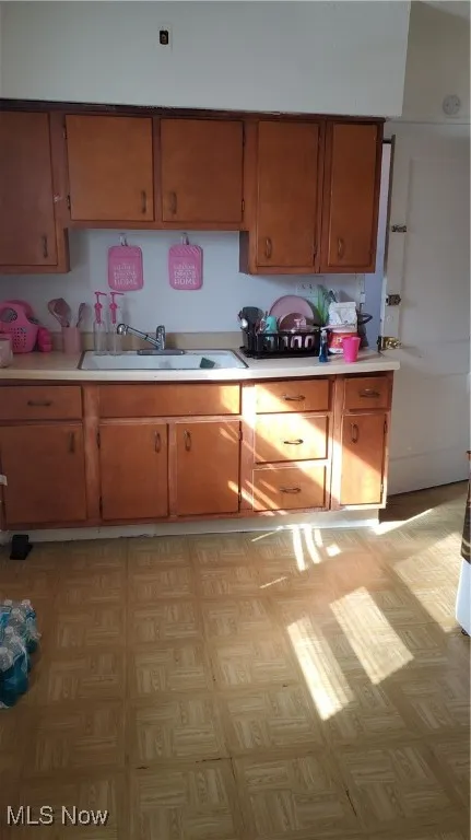 Kitchen featuring light countertops and brown cabinetry