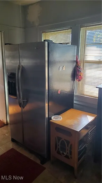 Kitchen featuring stainless steel refrigerator with ice dispenser and plenty of natural light