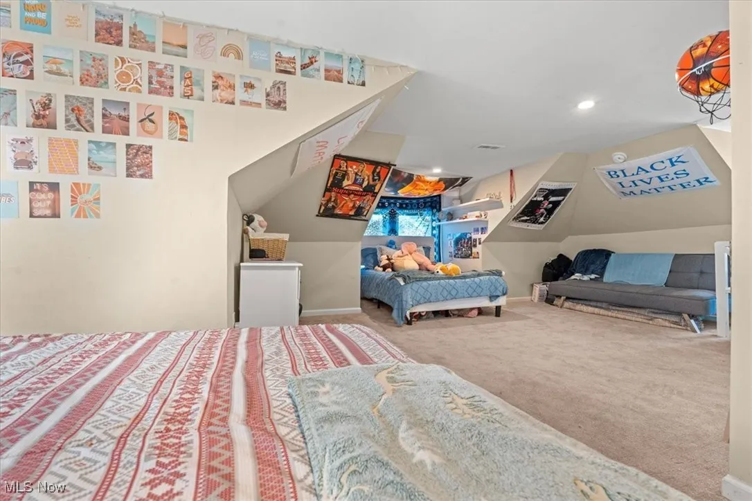 Carpeted attic featuring baseboards and recessed lighting