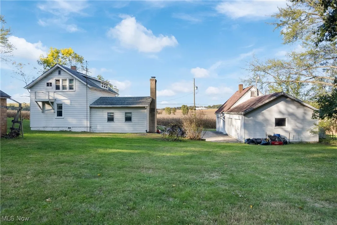 Back of house with a yard and crawl space