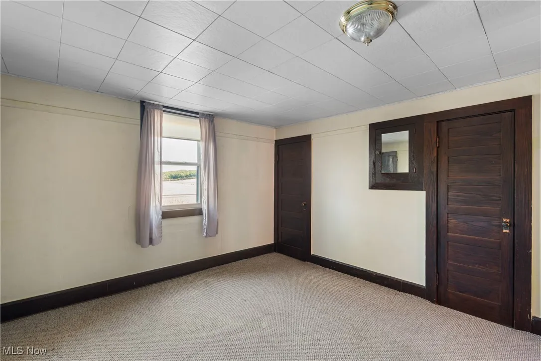 Carpeted empty room with baseboards