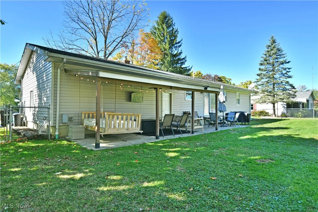Rear view of property featuring a patio, a chimney, and a gate
