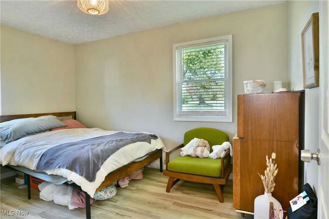 Bedroom featuring a textured ceiling and wood finished floors
