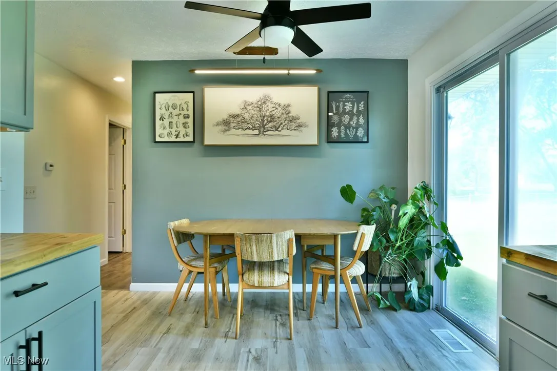 Dining area featuring a ceiling fan, light wood-style flooring, recessed lighting, and a textured ceiling