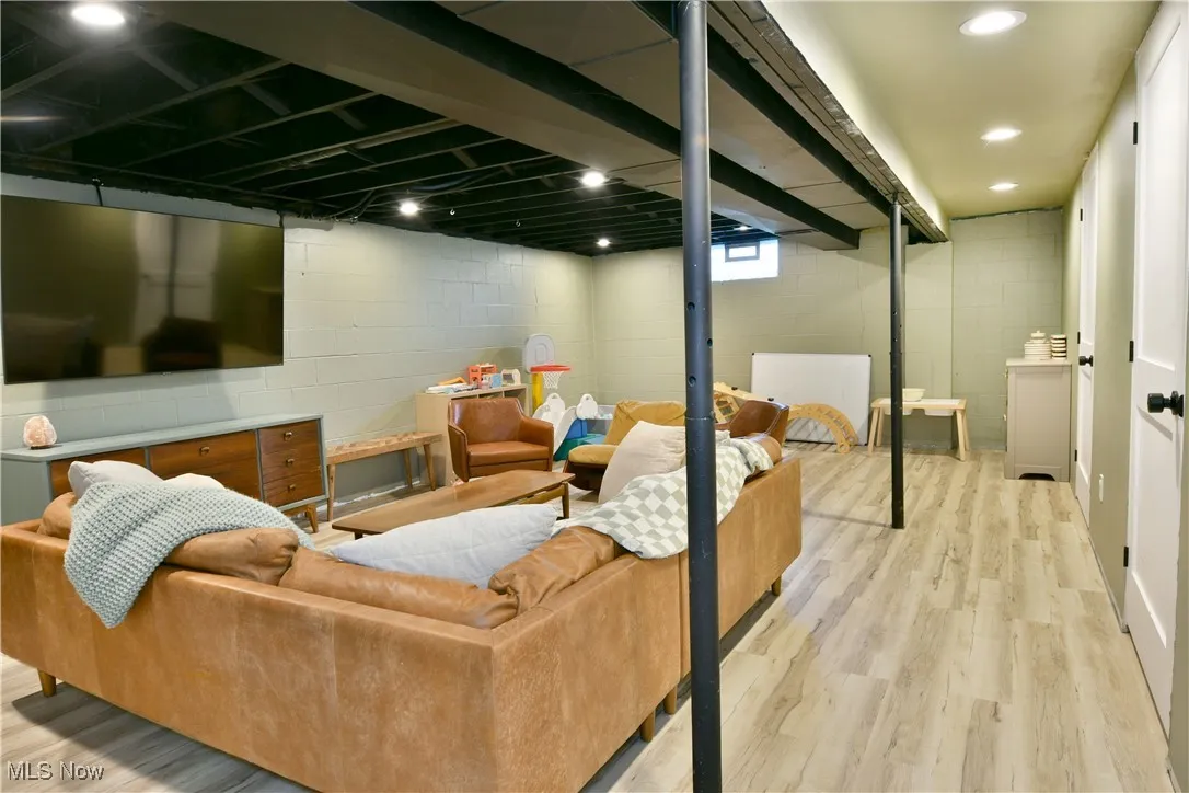 Below grade area with light wood finished floors and recessed lighting