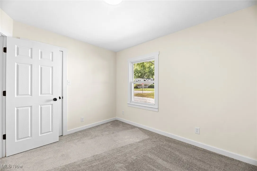 Empty room featuring light carpet and baseboards