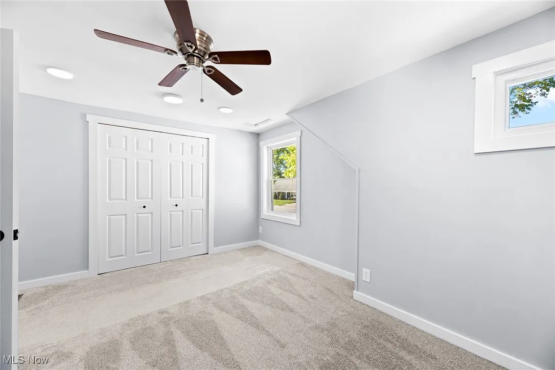 Unfurnished bedroom with carpet, a closet, and ceiling fan