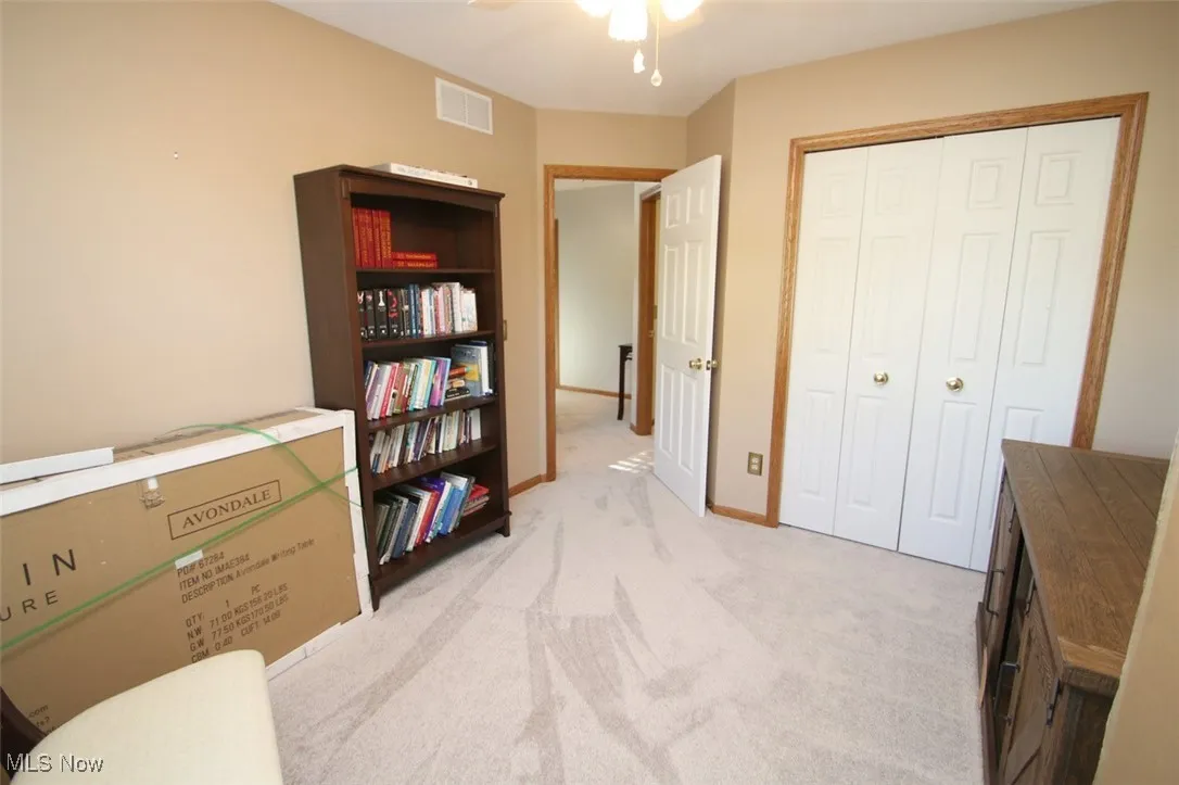 Living area featuring light carpet and ceiling fan