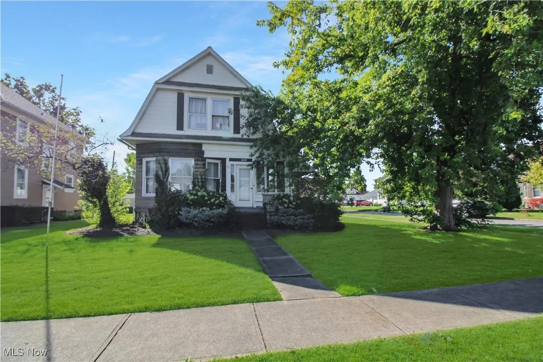 View of front facade featuring a front lawn and a gambrel roof