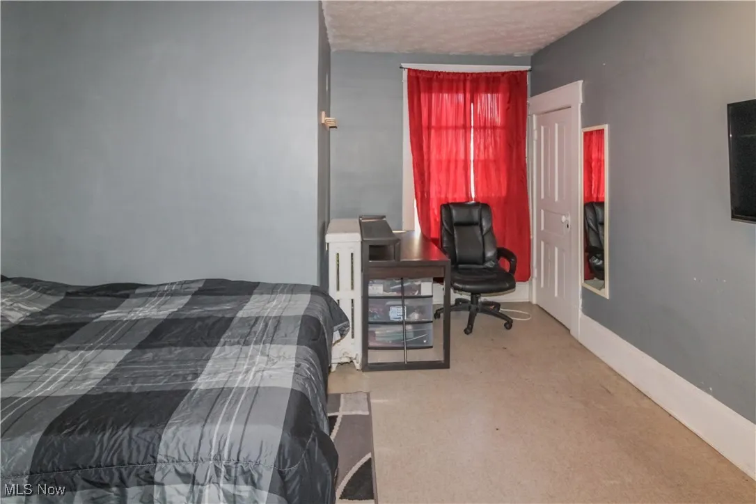 Bedroom with light carpet and a textured ceiling