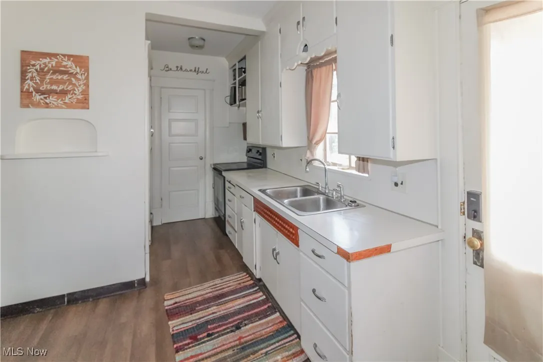 Kitchen featuring white cabinets, light countertops, and electric stove