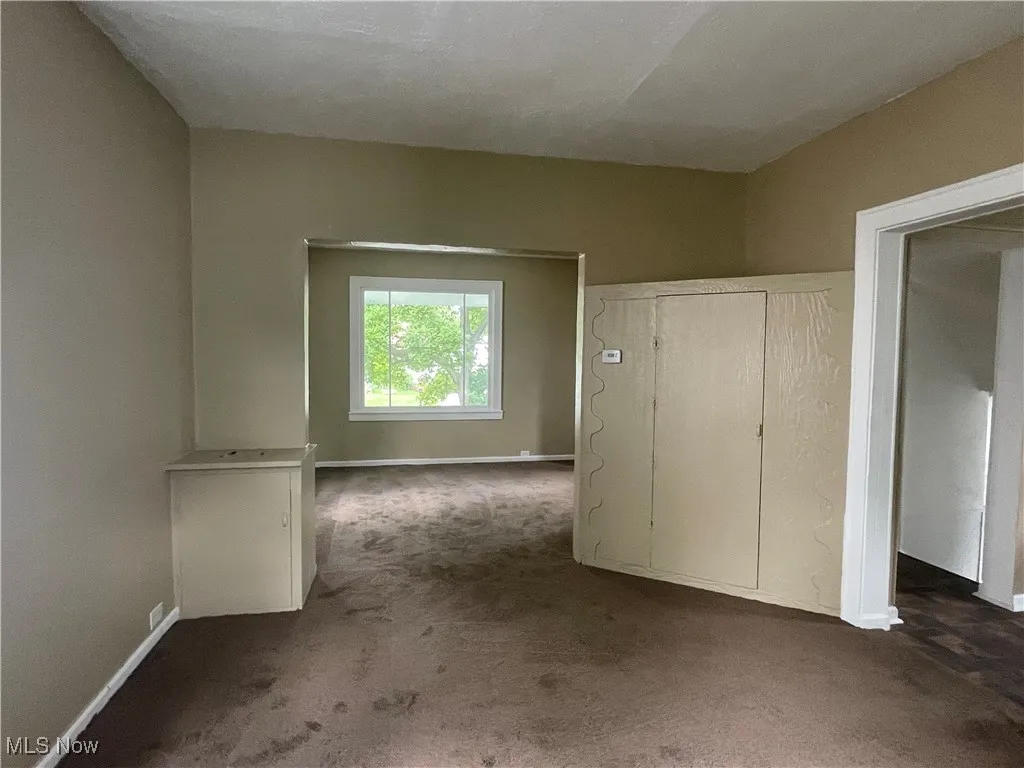 Unfurnished bedroom with carpet and baseboards