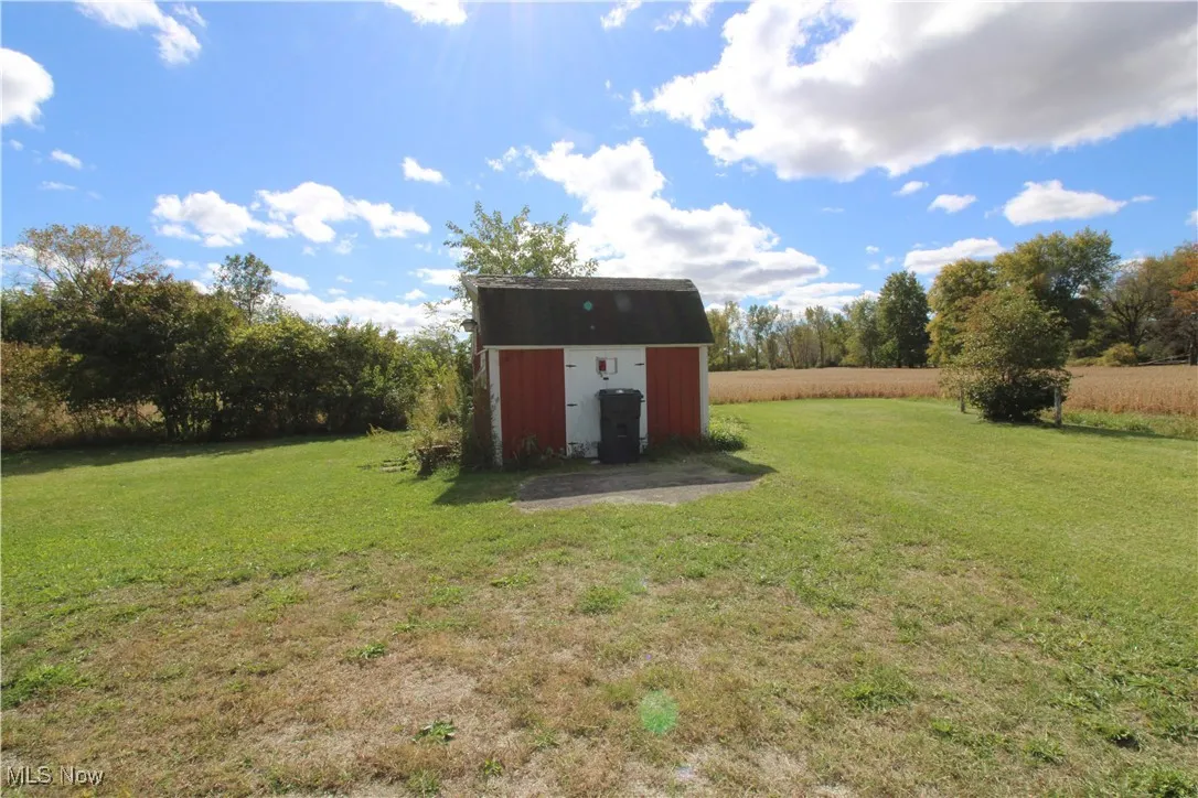 View of green lawn featuring a shed
