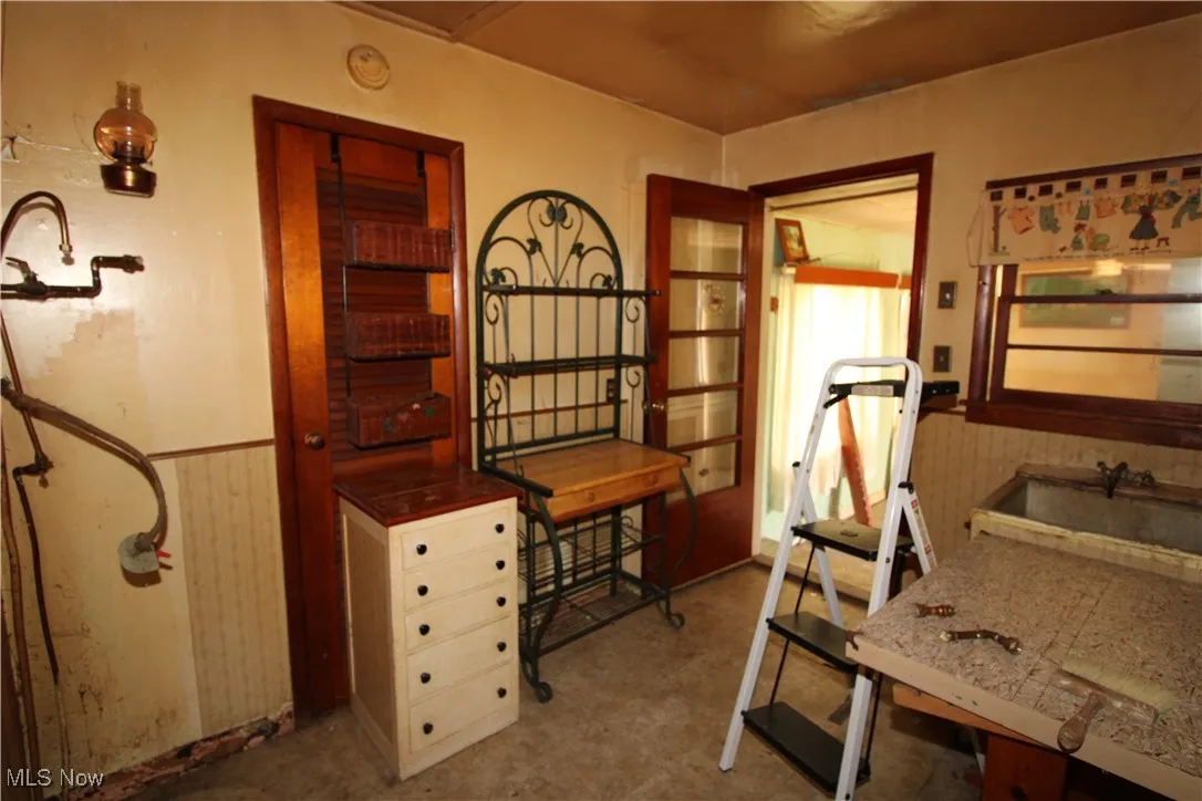 Office space with a wainscoted wall, wallpapered walls, and wood walls
