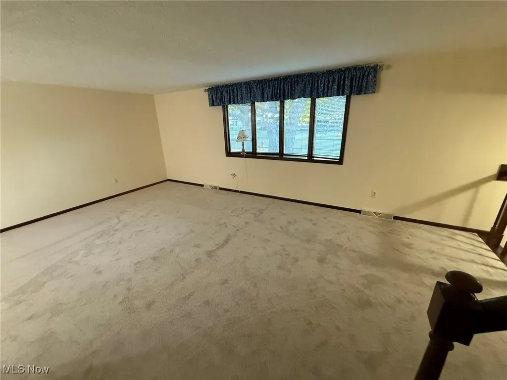 Unfurnished room featuring carpet flooring and baseboards