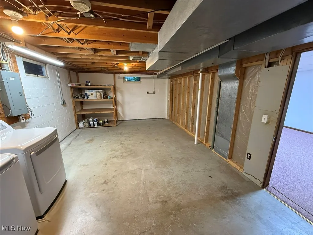 Below grade area featuring electric panel and washing machine and dryer
