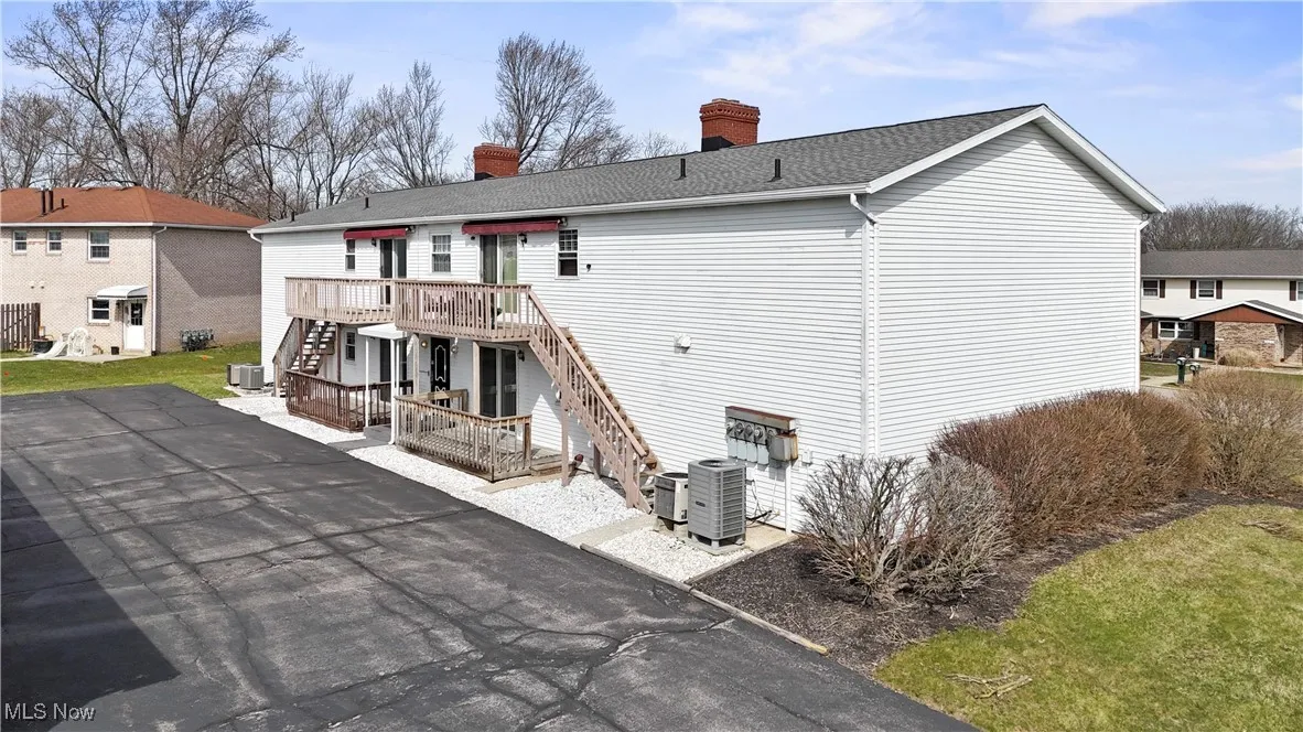 Rear view of property with stairway, a deck, a chimney, and a patio