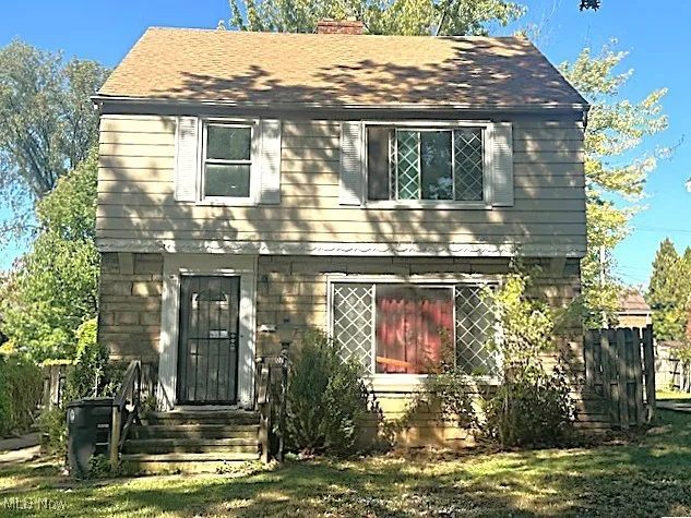 View of front of home featuring a chimney and roof with shingles