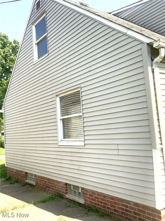 View of side of home featuring roof with shingles