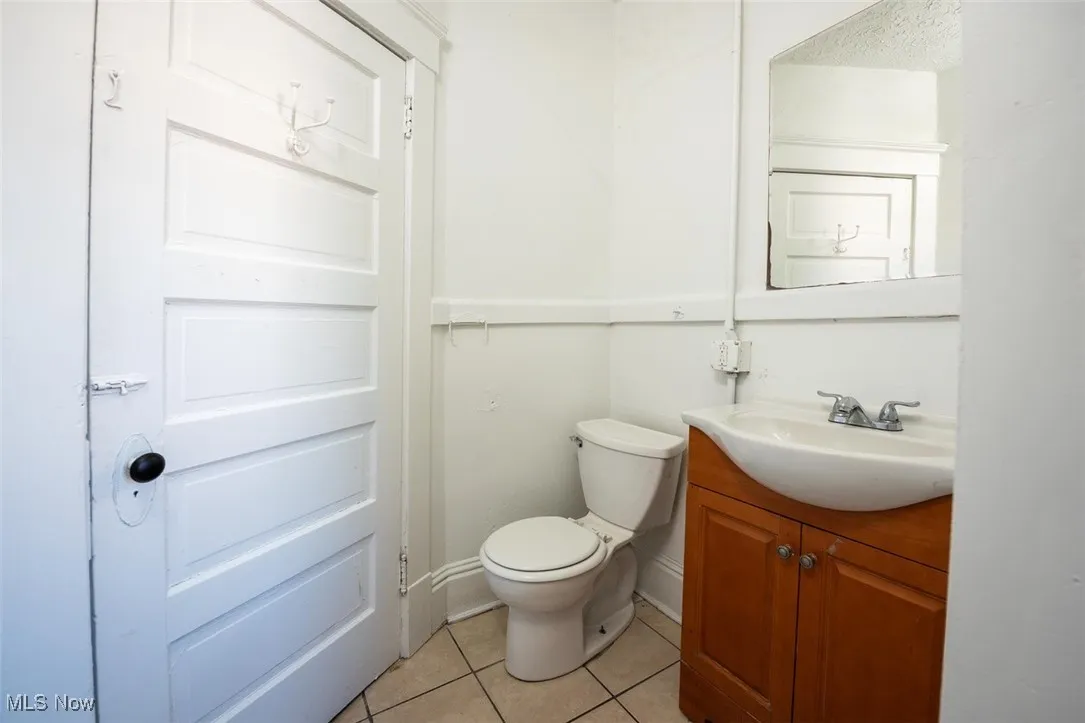 Half bathroom with light tile patterned floors and vanity