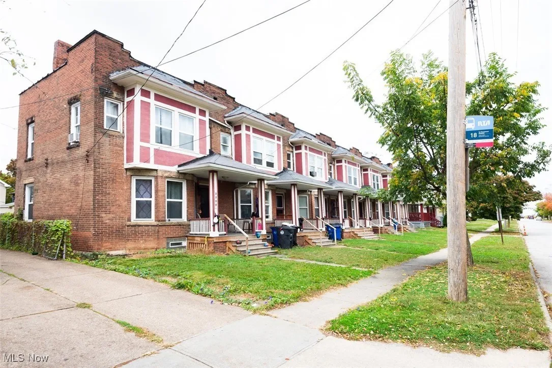 View of front of property featuring a front lawn, brick siding, and a porch