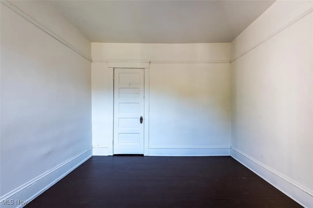 Spare room featuring dark wood finished floors and baseboards