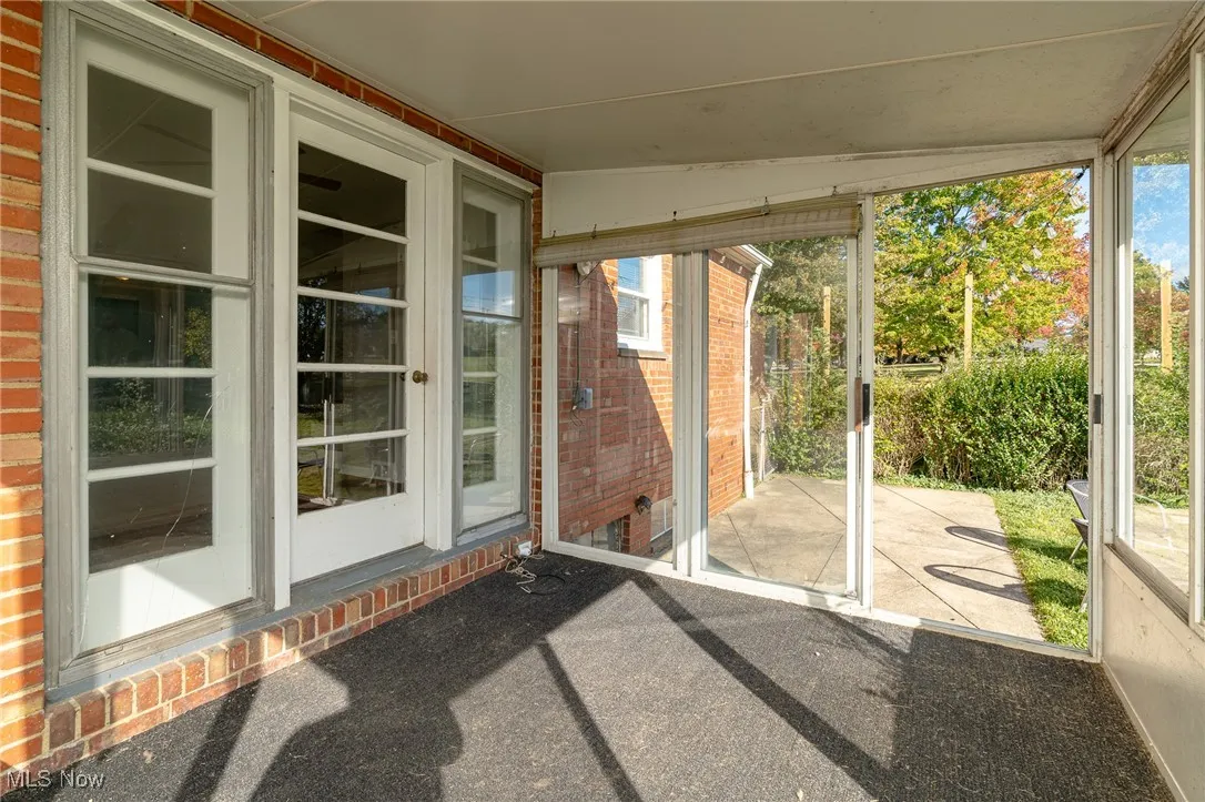 Unfurnished sunroom featuring healthy amount of natural light and lofted ceiling