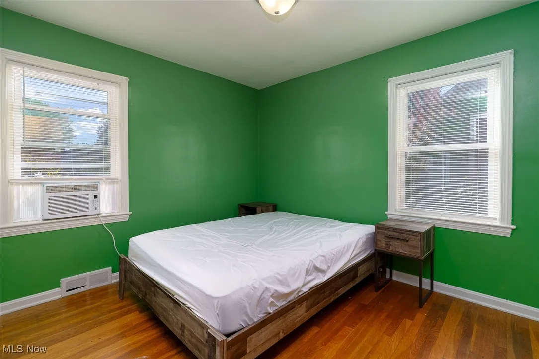 Bedroom with wood finished floors and cooling unit