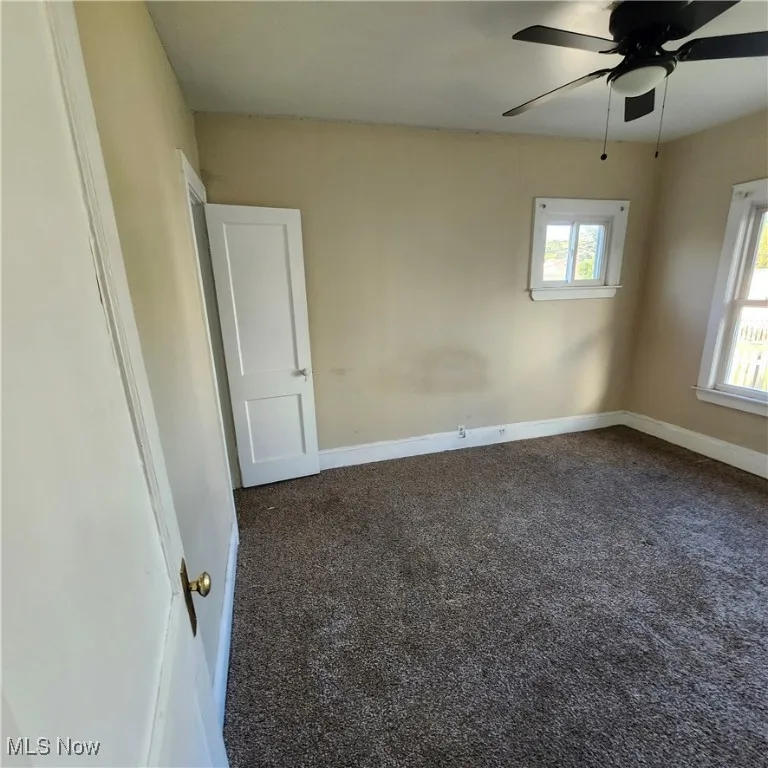 Empty room with carpet flooring and ceiling fan