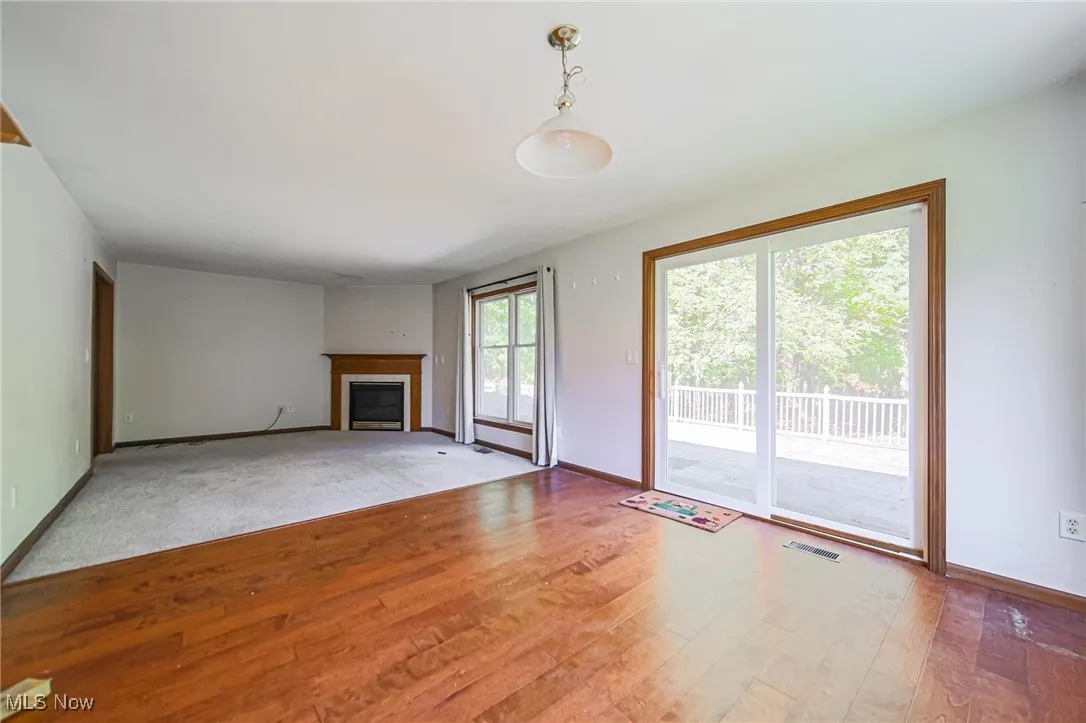 Unfurnished living room featuring light wood-style flooring and a fireplace