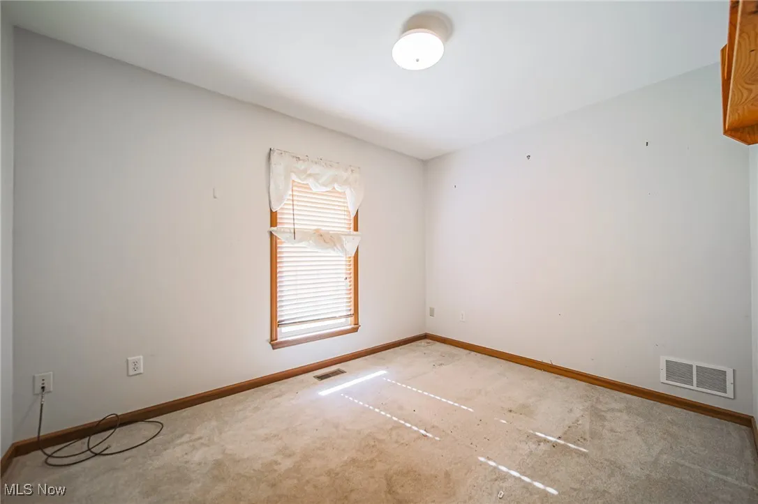 Empty room featuring baseboards and carpet floors