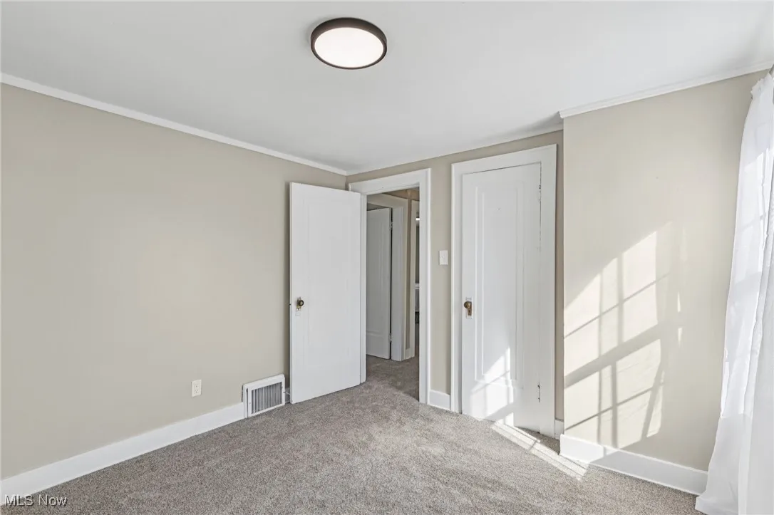 Unfurnished bedroom featuring carpet flooring and crown molding