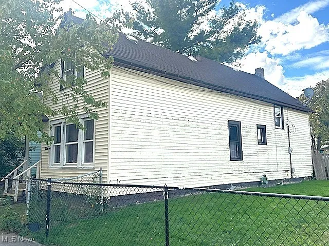 View of home's exterior featuring a fenced backyard and a chimney