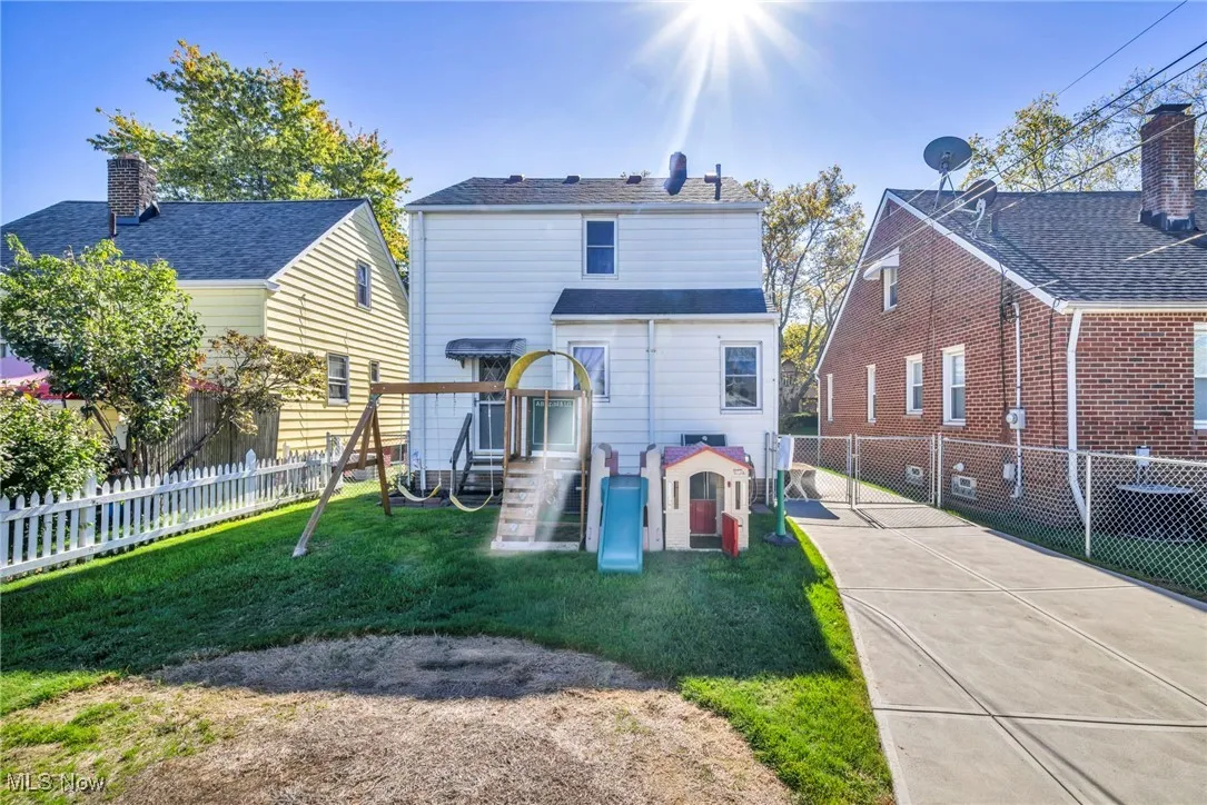 Rear view of property featuring a playground